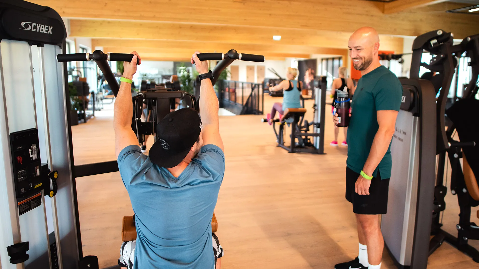 Mehrere motivierte Menschen trainieren an den Kraftgeräten.